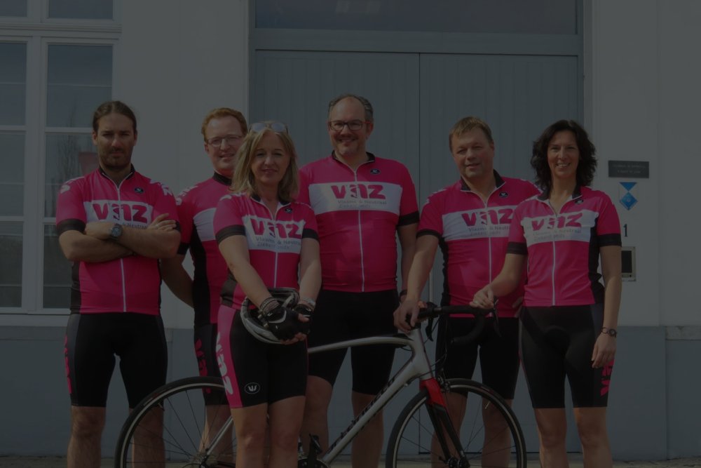 Medewerkers van VNZ in wielertenue voor het kantoor